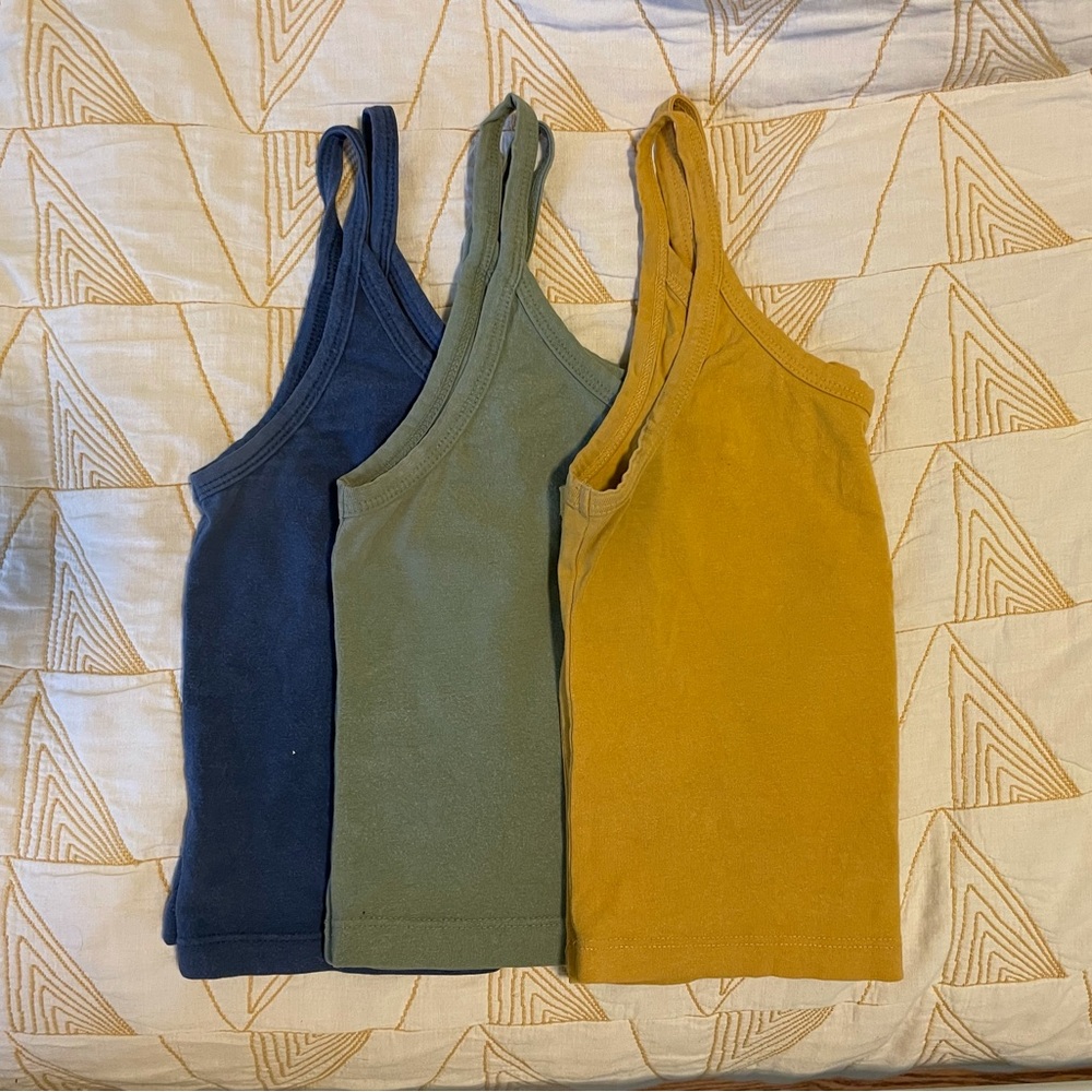 Three ARQ crop tanks, yellow, blue and green, size XS